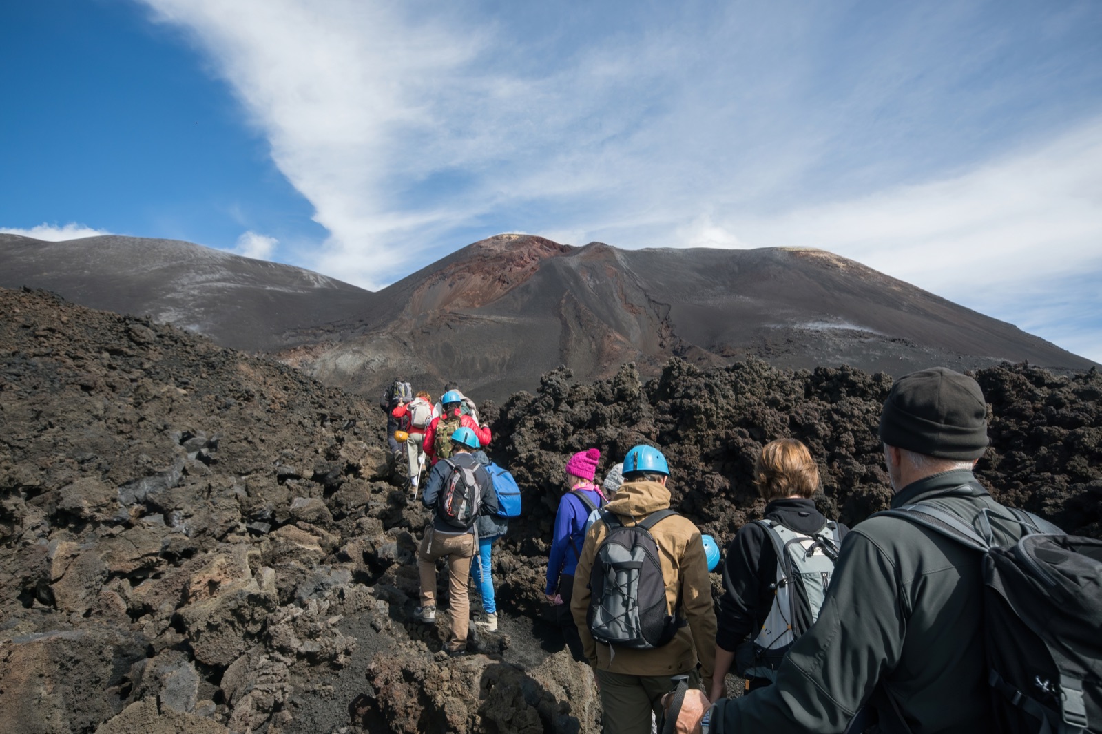 Walkers on a volcanic track high on Mount Etna